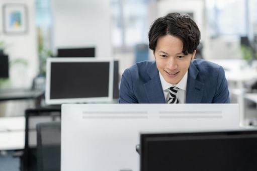オフィスで仕事をする若いビジネスマン オフィスで仕事をする若いビジネスマンの写真