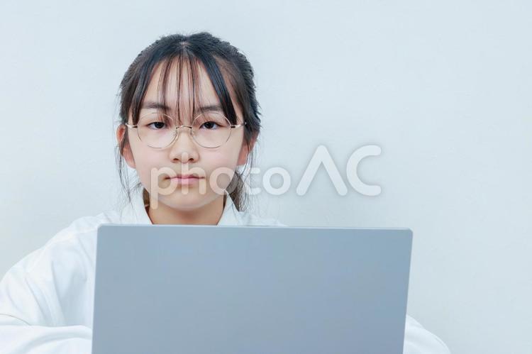PCを操作するカメラ目線の眼鏡女子 女性,小学生,少女の写真素材