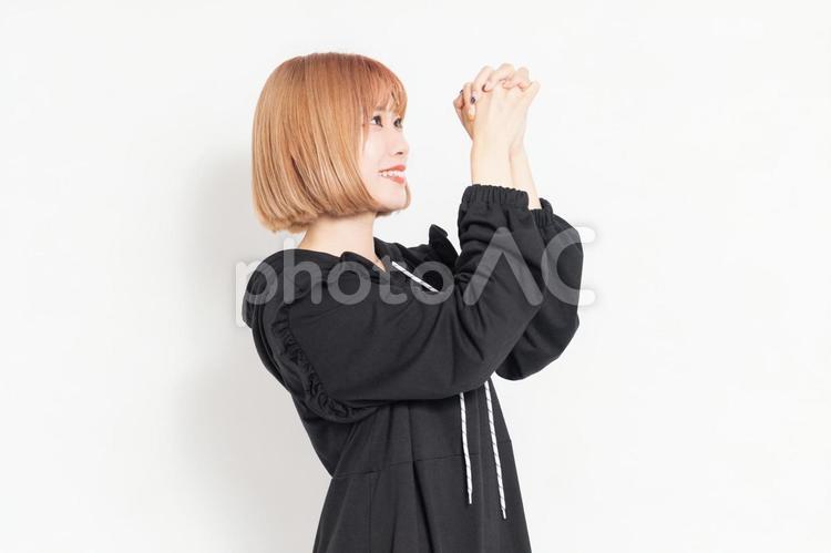 お願いのジェスチャーをするカジュアルな服装の若い女性 お願い,祈る,祈りの写真素材