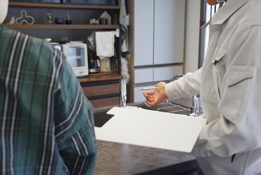 業者の男性から水道の説明を受ける女性 業者の男性から水道の説明を受ける女性 キッチン,台所,水回りの写真素材