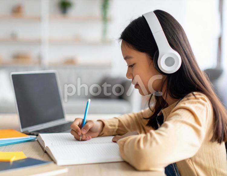 お気に入りの音楽を聴きながら勉強する女性 勉強,ノートパソコン,女性の写真素材