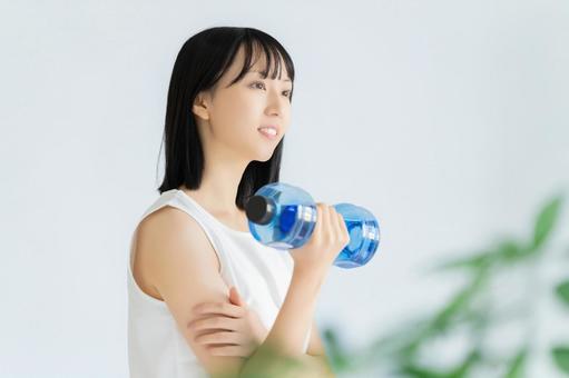 ダンベルでトレーニングをする若い女性 女性,美容,健康の写真素材