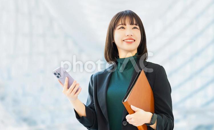 スマホを持つ笑顔の女性・ビジネスウーマン 女性,スマホ,ビジネスの写真素材