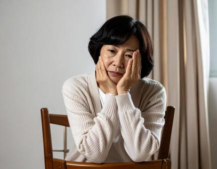 疲れた表情で休むシニアの日本人女性 疲れた表情で休むシニアの日本人女性の写真