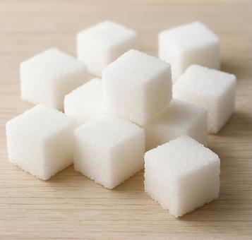 木のテーブルに並べられた角砂糖の写真