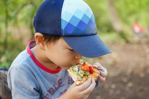 キャンプでピザを食べる子ども キャンプでピザを食べる子ども キャンプ,子供,こどもの写真素材