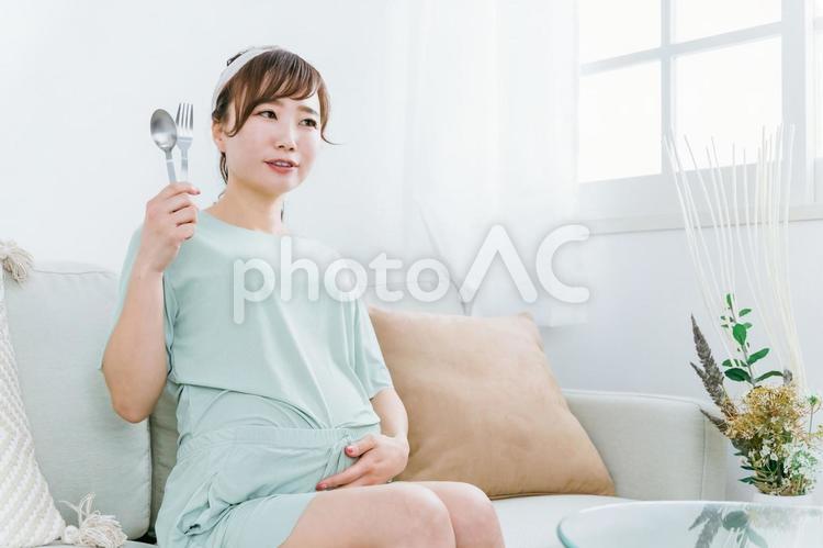 スプーンとフォークを持つ日本人の妊婦 妊婦,肥満,大食いの写真素材