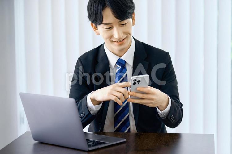 スマホを見るビジネスマン　仕事　職場 ビジネスマン,スマホ,オフィスの写真素材
