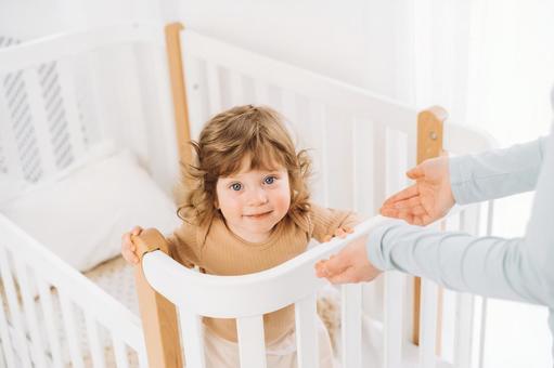 カメラ目線の笑顔の子供と抱っこしようとする手 カメラ目線の笑顔の子供と抱っこしようとする手 赤ちゃん,かわいい,ベビーベッドの写真素材