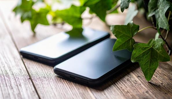 連絡交換のイメージ　机の上の携帯電話二台の写真