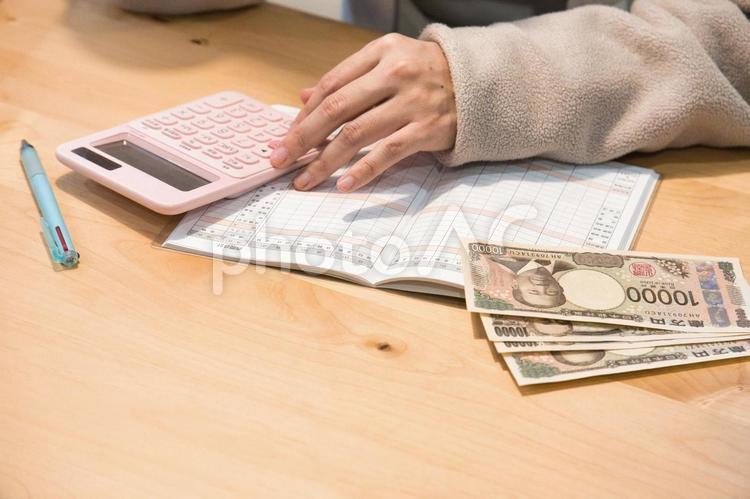 家計簿で収我が家の収支を管理する主婦 貯金,家計簿,お金の写真素材