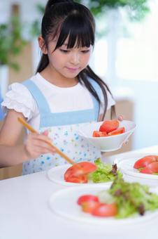 彩りサラダを盛り付ける朝の食卓の写真