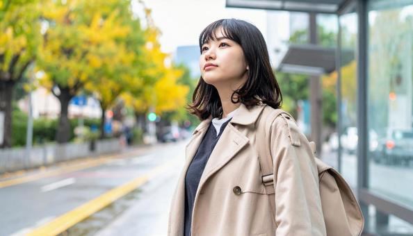 雨の中バス停でバスを待つ日本人女性 雨の中バス停でバスを待つ日本人女性の写真