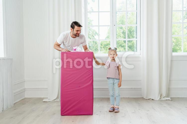 娘を見る父とカメラ目線の女の子 親子,笑顔,嬉しいの写真素材