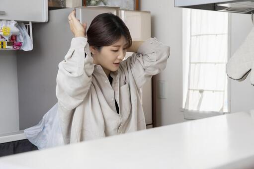 キッチンで髪を結ぶ女性 キッチン,料理,主婦の写真素材