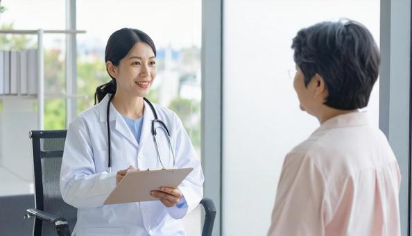 患者女性に説明する日本人医師 患者女性に説明する日本人医師の写真