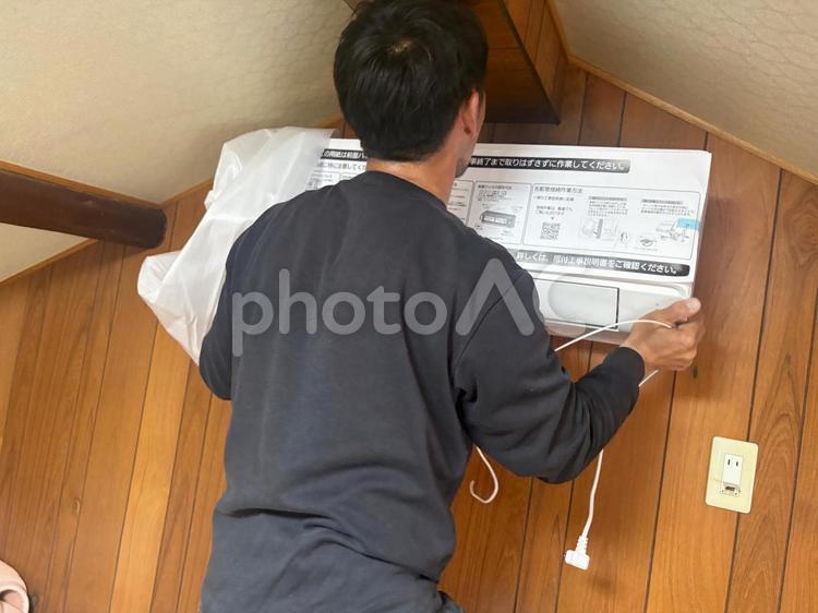 エアコン工事で室内機を取り付けする男性 エアコン工事,室内機,エアコンの写真素材
