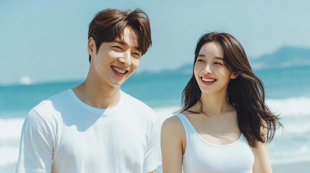 ビーチで笑い合う若いカップル ビーチで笑い合う若いカップルの写真