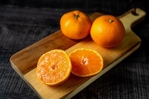 カットしたミカンと丸のミカン みかん,果物,カッティングボードの写真素材