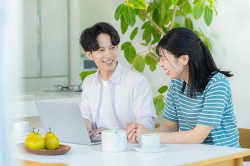パソコンを見るカップル ノートパソコン,笑顔,カップルの写真素材