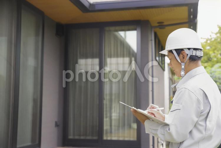 住まいのチェックをする建築士男性 住宅点検,外観点検,ホームインスペクションの写真素材