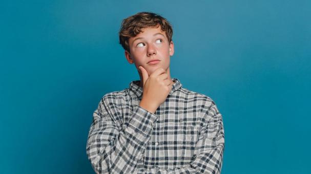 疑問を抱き、熟考する少年 疑問を抱き、熟考する少年の写真