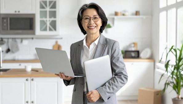 台所でPCを持つ不動産業の女性 台所でPCを持つ不動産業の女性の写真