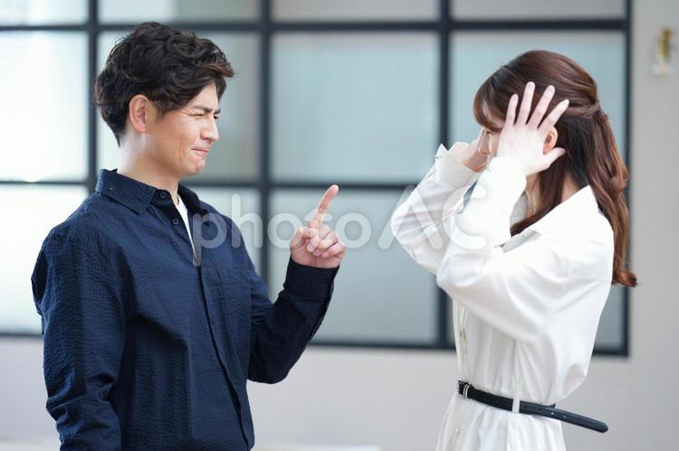 女性に注意をする男性 男女,指差し,注意の写真素材