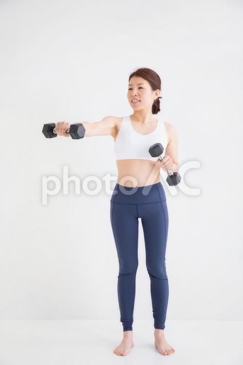 スポーツウェアを着た女性 筋トレ,ダンベル,女性の写真素材