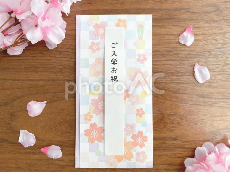 机上に置いた入学祝いの祝儀袋と桜 入学,お祝い,祝儀袋の写真素材