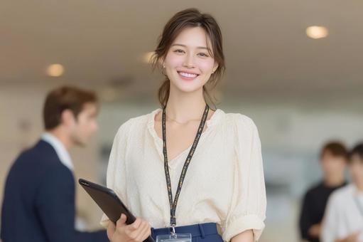 タブレットを持ちプレゼンに挑む女性の写真