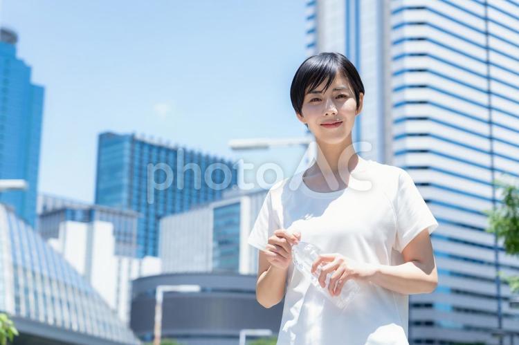 オフィス街をジョギングする若い女性 ランニング,ジョギング,フィットネスの写真素材