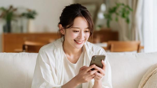 スマホを楽しむ女性の写真