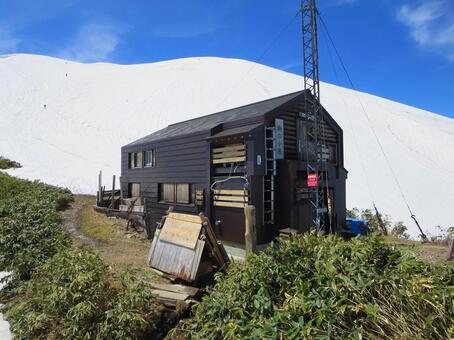残雪の越後駒ヶ岳と駒の小屋 越後駒ヶ岳,駒の小屋,山小屋の写真素材