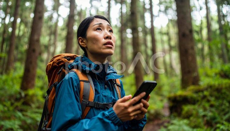 森の中で不安げに立ち止まる登山女性 女性,登山,森の写真素材