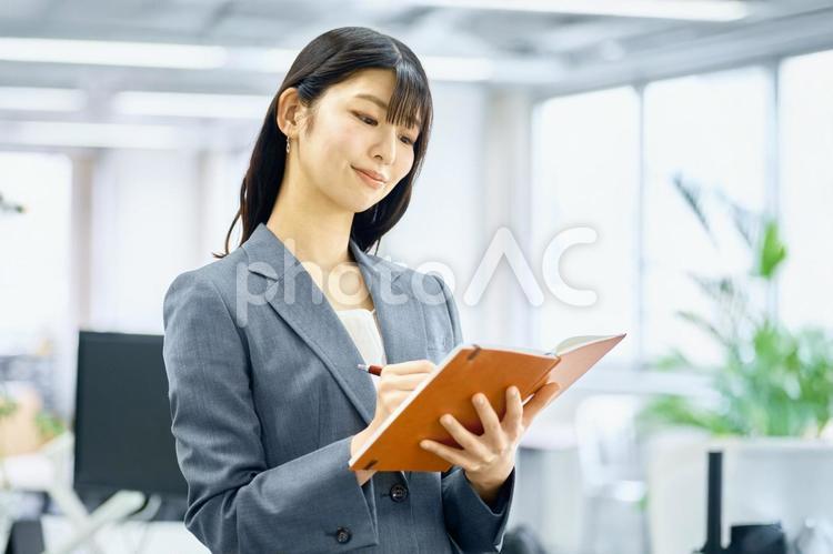 メモをとるビジネスウーマン　オフィス ビジネスウーマン,手帳,オフィスの写真素材