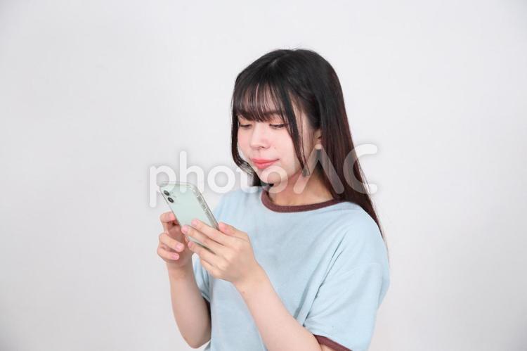 部屋着でスマートフォンを操作する女性 女性,若い,20代の写真素材