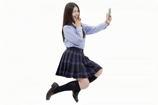 女子高校生 ジャンプ スマートフォン 女子高校生 ジャンプ スマートフォン 人物,女性,女子高生の写真素材