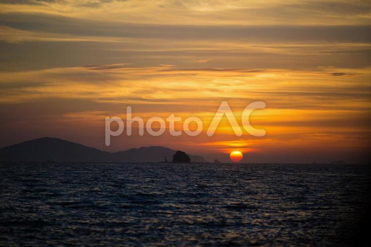 水平線に沈む太陽と島と船 太陽,夕陽,水平線の写真素材