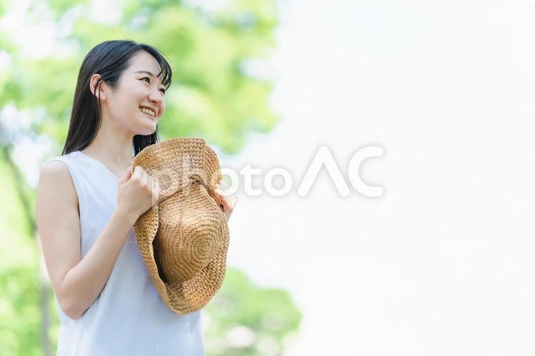 麦わら帽子を持つ女性（夏・笑顔） 夏,女性,旅行の写真素材