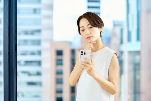 スマホを持つビジネスウーマン オフィス スマホを持つビジネスウーマン オフィス ビジネスウーマン,スマホ,女性の写真素材