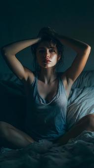 夜中に悩み、頭を抱える女性 夜中に悩み、頭を抱える女性の写真