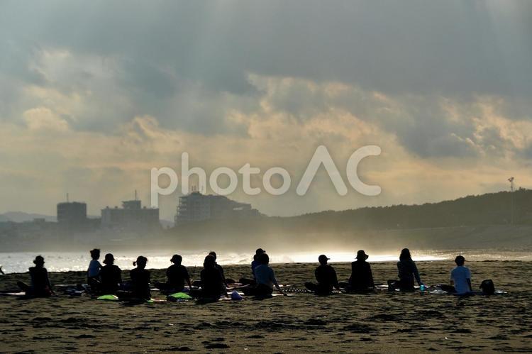 夕暮れの砂浜のビーチヨガ（シルエット） 風景,砂浜,ビーチヨガの写真素材