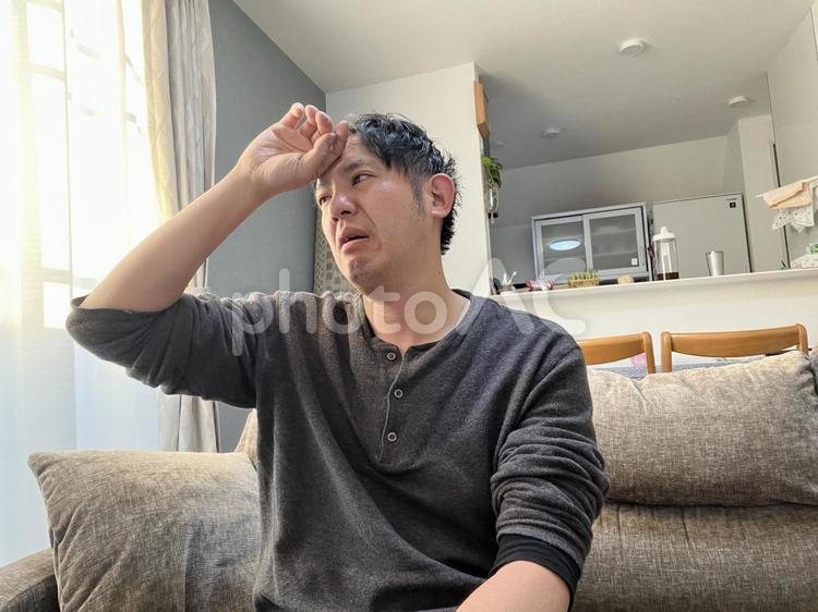 手を額に当てる男性　2 手,額,熱の写真素材
