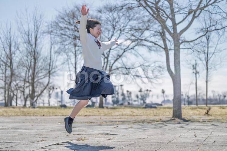 両手を広げてジャンプする学生 女子学生,制服,ジャンプの写真素材