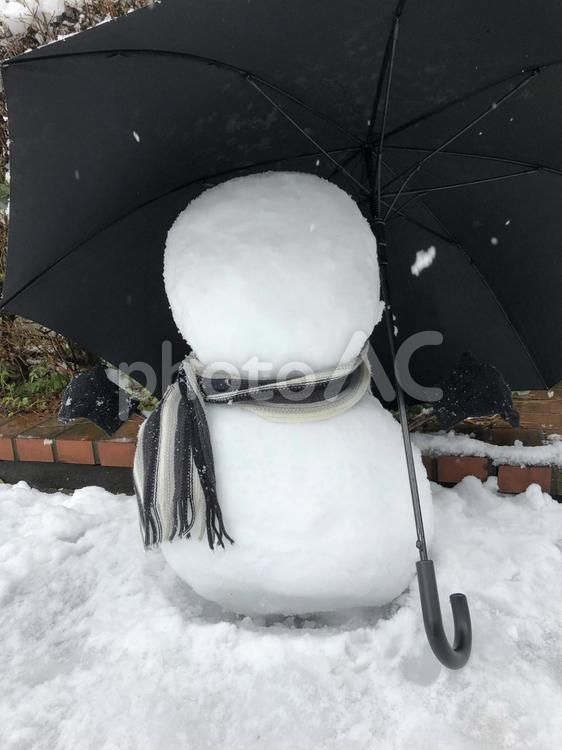傘をさして暖かい格好の雪だるま 雪だるま,マフラー,傘の写真素材