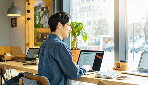 カフェで仕事をするフリーランス男性 カフェで仕事をするフリーランス男性の写真
