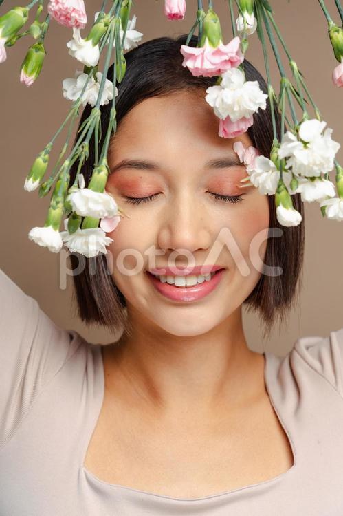 カーネーションと目を瞑る笑顔の女性 女性,カーネーション,白の写真素材