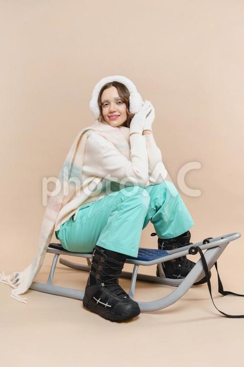 ソリに乗っているカメラ目線の女性 冬,スポーツ,ウィンタースポーツの写真素材