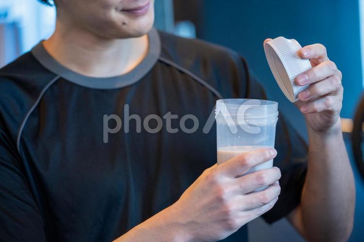 ジムでプロテインを飲む日本人男性 プロテイン,ジム,休憩の写真素材